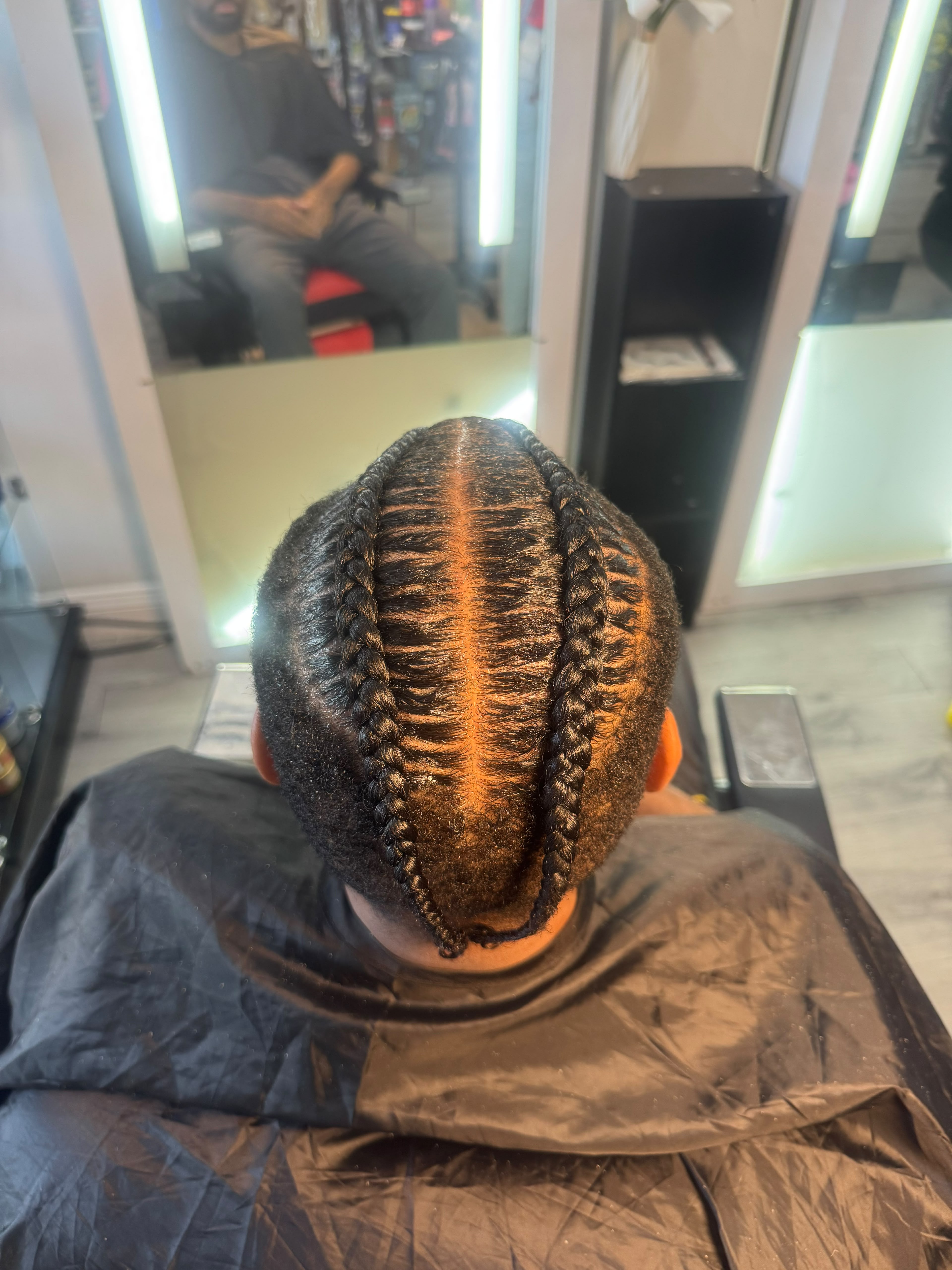 Zigzag stitch cornrows with sharp clean parting on a male client at Stella Braids and Hair Studio in Covina